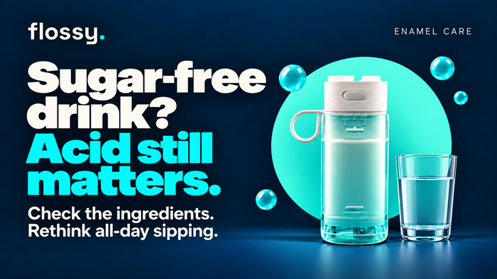 Flossy water flosser beside a plain drinks glass on the established navy background.