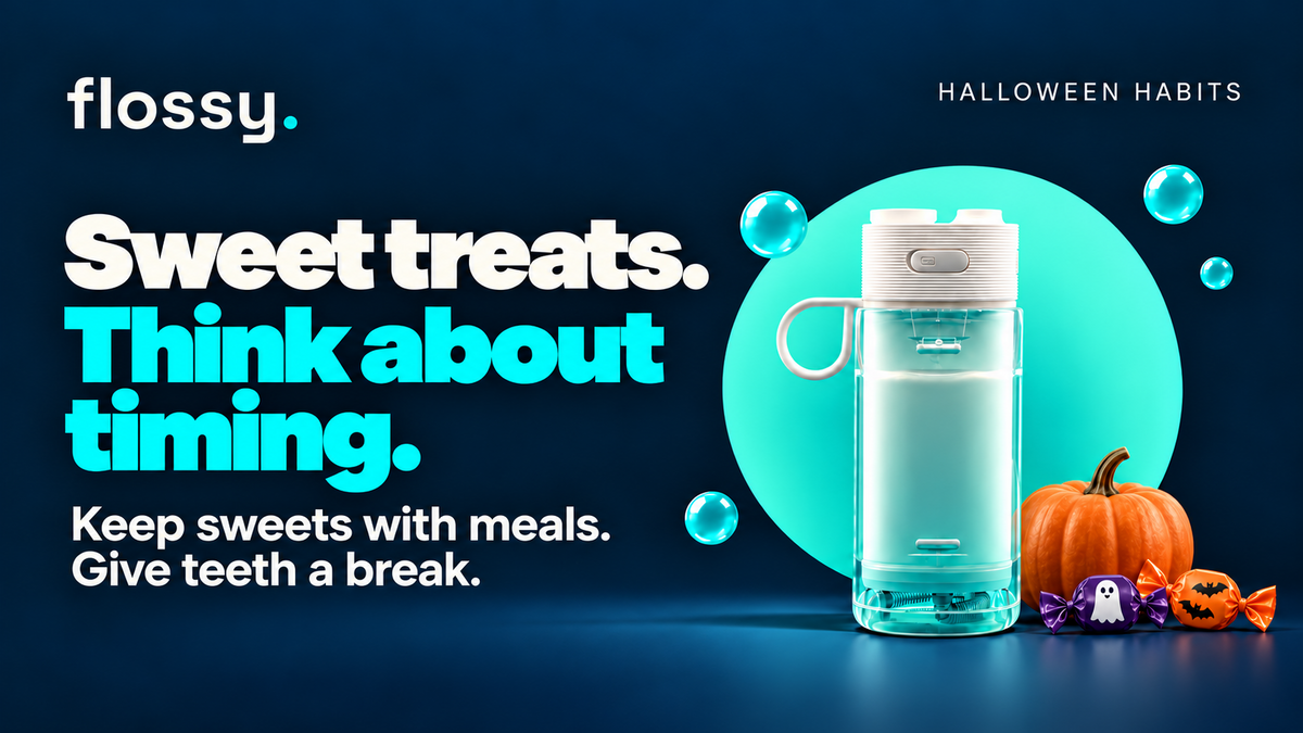 Flossy water flosser beside a small pumpkin and wrapped sweets on the established navy background.